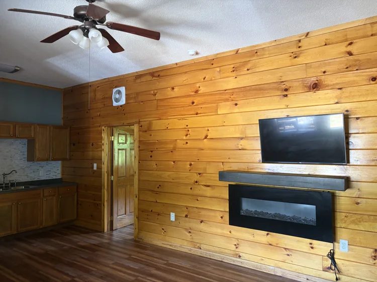 Living room with pine walls, a wall-mounted TV and an electric fireplace
