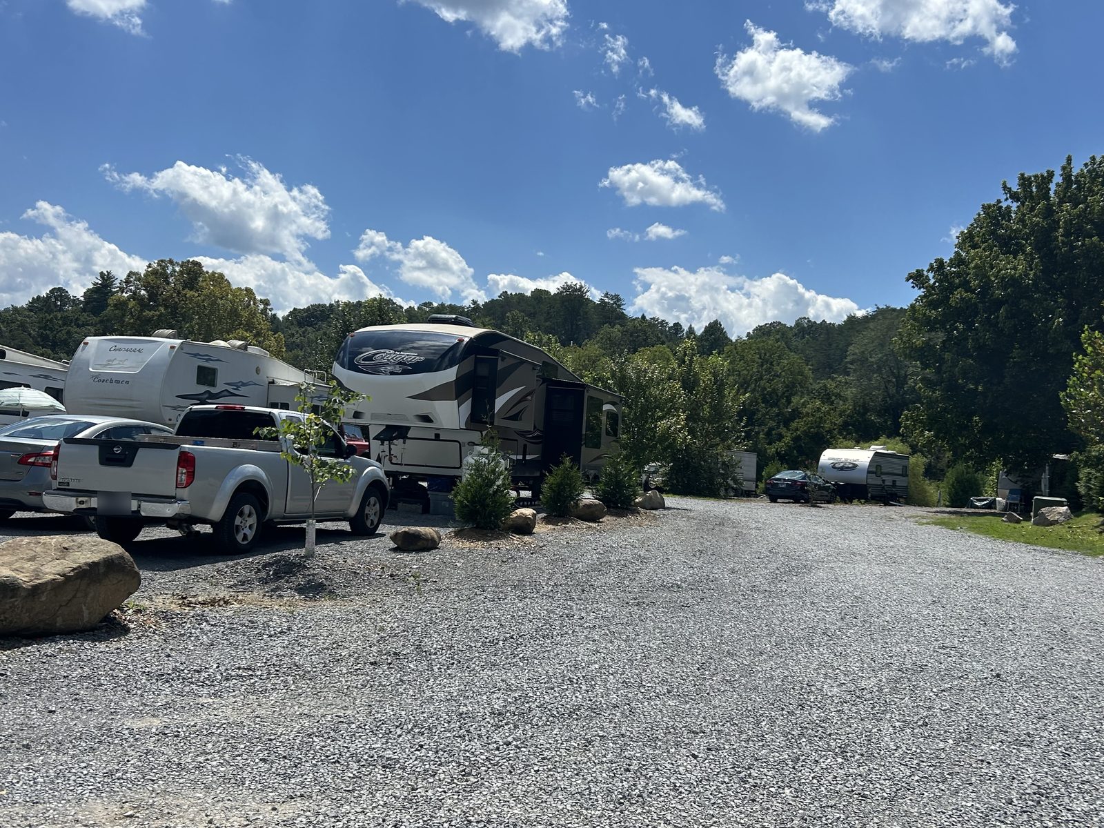The gravel drive between RV lots, lined with young trees and boulders